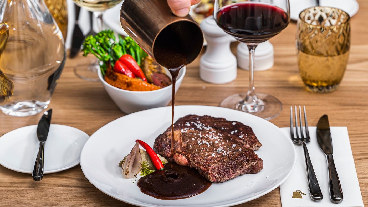 Beef steak with a glass of red wine in The Julius Prague