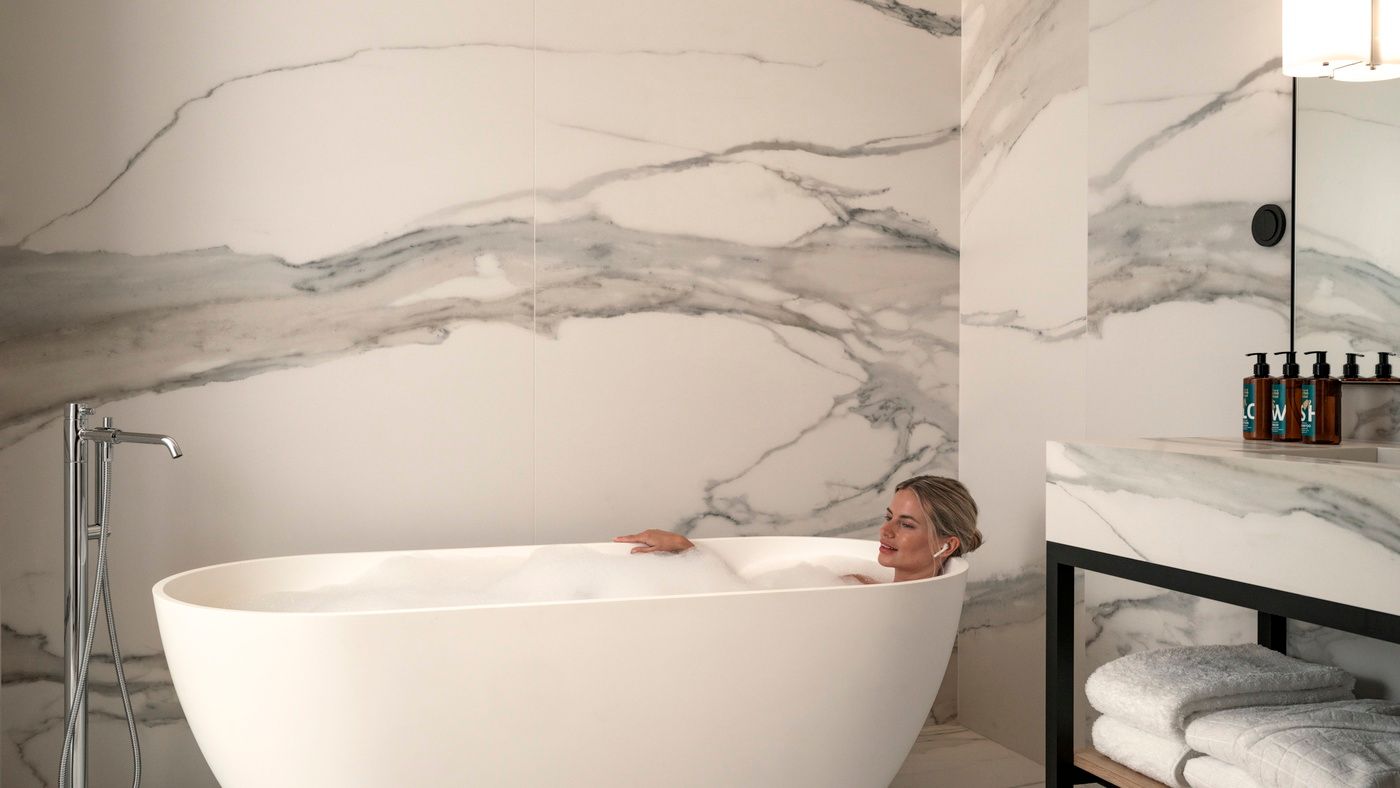 Woman in bathtub in Deluxe One Bedroom Suite with bathtub