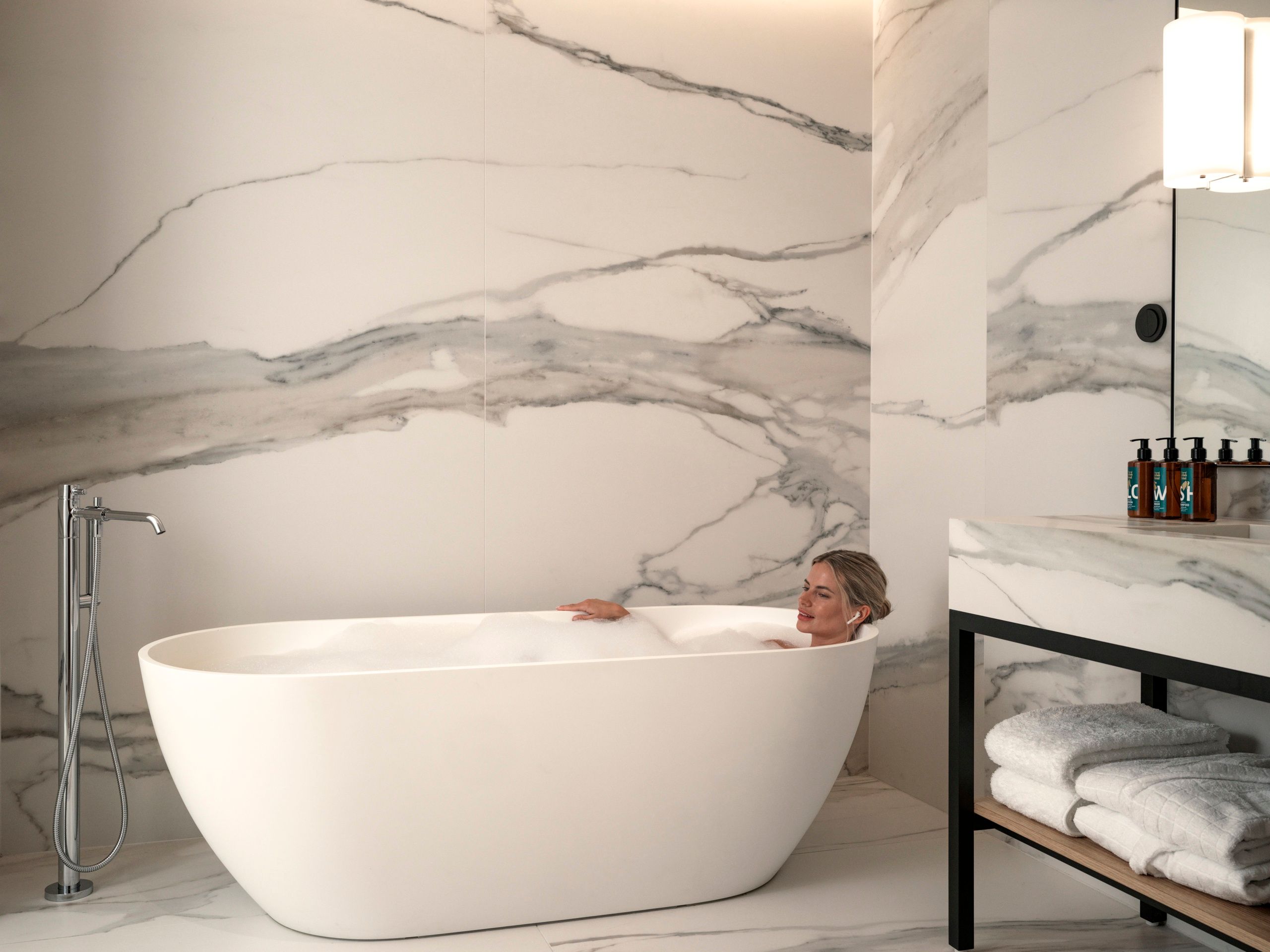 Woman in bathtub in Deluxe One Bedroom Suite with bathtub 