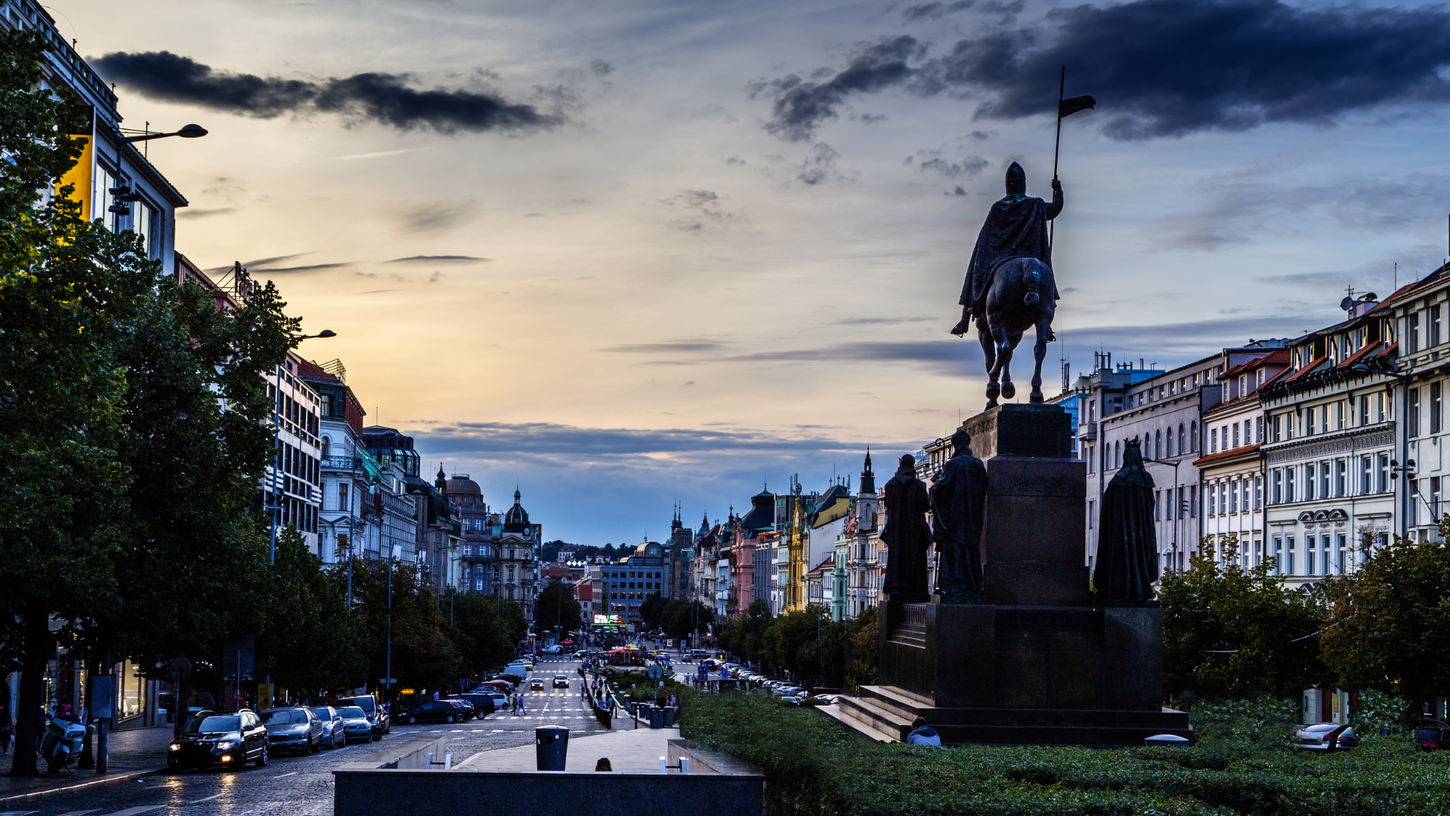 Wenceslas Square Tranquility at Sunset: An enchanting scene of Wenceslas Square, Prague, captured in the serene moments of a vivid sunset. The cold, calming colors of the evening sky provide a striking backdrop to the square's silhouette, adorned with a statue. The absence of crowds adds to the tranquility of this iconic location, allowing for a peaceful appreciation of its historic beauty.