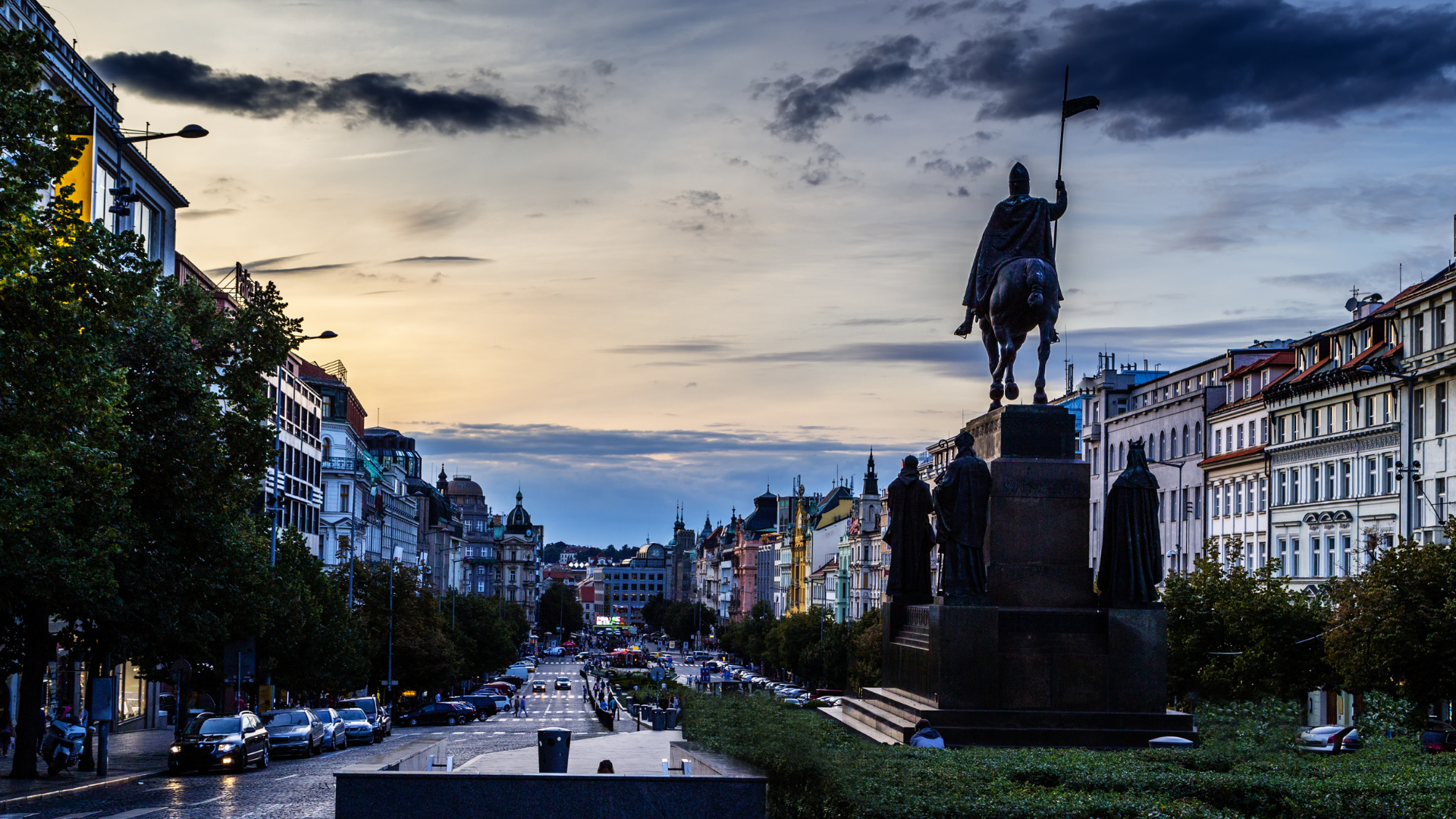 Wenceslas Square Tranquility at Sunset: An enchanting scene of Wenceslas Square, Prague, captured in the serene moments of a vivid sunset. The cold, calming colors of the evening sky provide a striking backdrop to the square's silhouette, adorned with a statue. The absence of crowds adds to the tranquility of this iconic location, allowing for a peaceful appreciation of its historic beauty. 