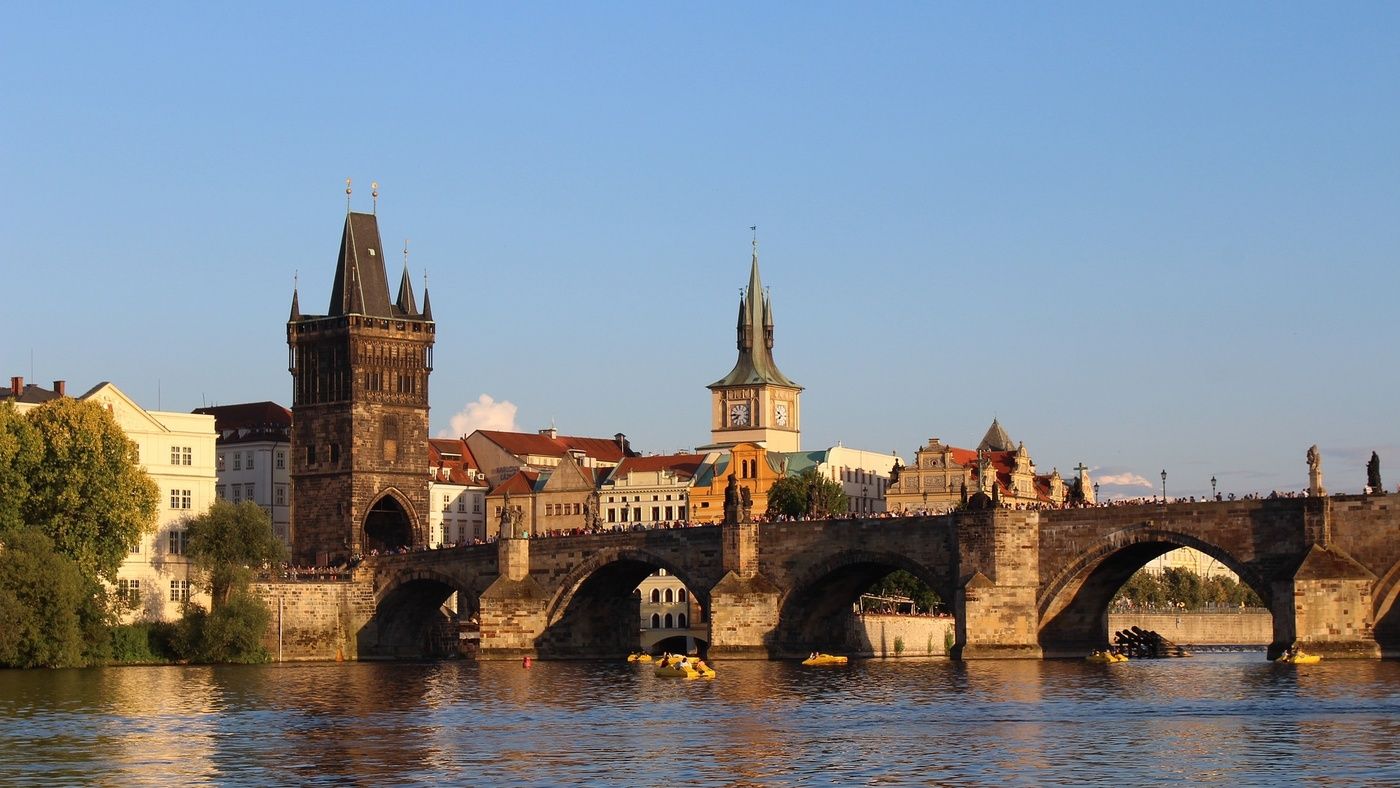 Sunny Day at Charles Bridge: Bask in the sunshine on a glorious day at Prague's Charles Bridge. The blue sky provides a stunning backdrop to the historic bridge adorned with its iconic statues. Visitors and locals alike stroll along this iconic landmark, enjoying the vibrant atmosphere of this Czech treasure