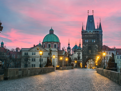  Vivid Pink Dusk at Charles Bridge: Experience the magical allure of Charles Bridge at dusk as the sky turns vivid pink. The bridge, illuminated by warm lights, stands gracefully, inviting you to explore its historic charm in the tranquil evening hours