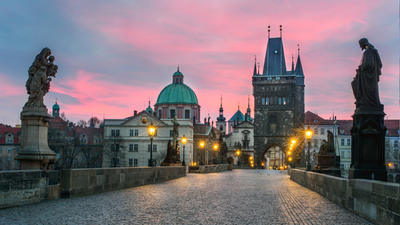  Vivid Pink Dusk at Charles Bridge: Experience the magical allure of Charles Bridge at dusk as the sky turns vivid pink. The bridge, illuminated by warm lights, stands gracefully, inviting you to explore its historic charm in the tranquil evening hours